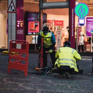 twee werkmannen leggen kabels aan in de grond